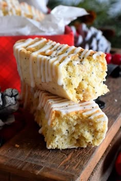 two pieces of cake sitting on top of a wooden cutting board next to christmas decorations