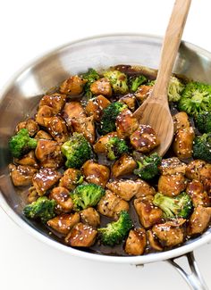 chicken and broccoli stir fry in a pan with a wooden spoon