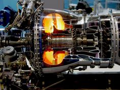 the inside of a machine with orange light coming out of it's center pipes