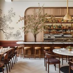 the interior of a restaurant with tables, chairs and bar stools in front of it