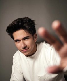 a young man making a hand gesture with his right hand in front of the camera