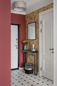 a room with red walls and a black table in the corner next to a white door