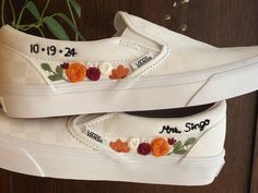 two white shoes with flowers painted on them