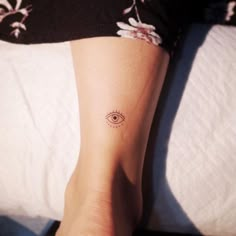 a woman's foot with an eye tattoo on it