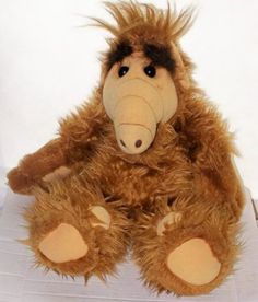 a brown stuffed animal sitting on top of a white surface