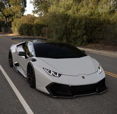 a white sports car is parked on the side of the road