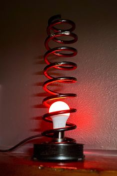 a light that is sitting on top of a table in front of a red wall