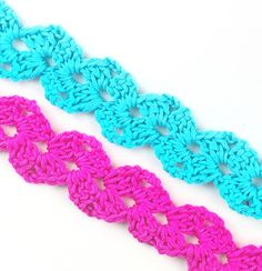 three crocheted pieces of different colors on a white surface, one is blue and the other is pink