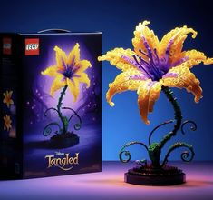 a yellow flower is in front of a purple box with the word tangled on it