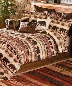 a bed with brown and white comforter in a bedroom next to a window filled with potted plants