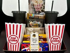 the popcorn box is filled with movies, snacks and movie tickets to be served in