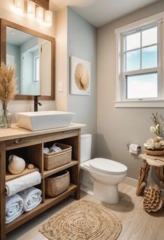 a white toilet sitting next to a wooden cabinet in a bathroom under a mirror above a sink