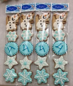 frosted cookies in the shape of snowmen and stars are displayed on a table