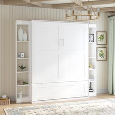 a living room with a large white bookcase next to a window and a rug on the floor