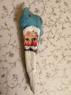 an old toothpick with a painted face on it's side sitting on a wall