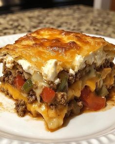 a piece of lasagna on a white plate with cheese and meat toppings