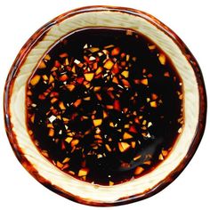 a brown and white bowl filled with food on top of a table