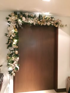 a wooden door decorated with white flowers and greenery on the front wall in a living room