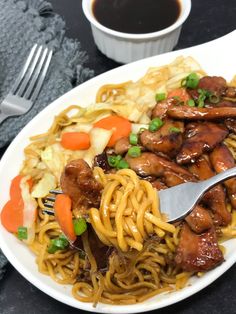 a white plate topped with noodles and meat next to a cup of black coffee on a table