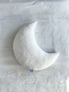 the moon pillow is white and has a blue tag on it's left side