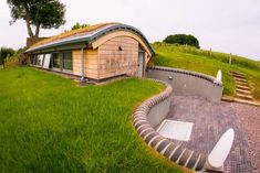 an unusual house sits on top of a hill