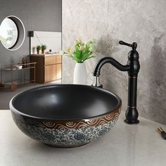 a black bowl sink sitting on top of a counter next to a faucet