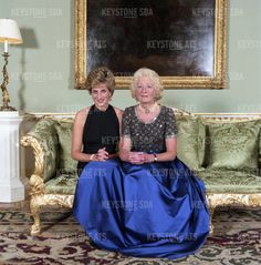 two women sitting on a couch in front of a painting