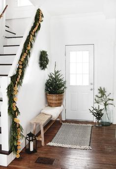 the stairs are decorated with garland and pine cones