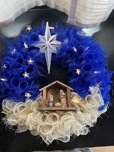 a christmas wreath with a nativity scene in the center and a star on top