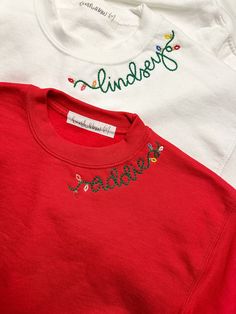 three t - shirts with embroidered words on them are sitting next to each other,