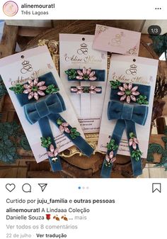 three pieces of blue ribbon with flowers on them are sitting in a wooden box next to each other