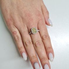 a close up of a person's hand with a ring on their finger and nails