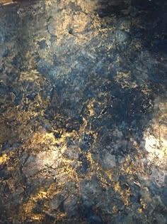 a close up view of the surface of a counter top with gold and black paint