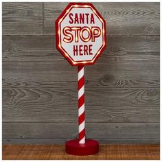 a lighted stop sign with the words santa here on it