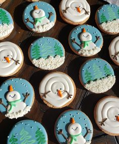 frosted decorated cookies with snowmen and trees on them are sitting on a table