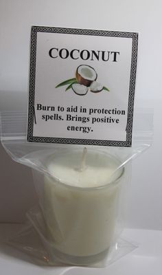 a candle with a label on it that says coconut burn to aid in protection spills bring positive energy