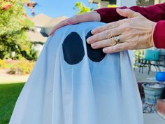 two hands holding onto a white sheet with black circles on it