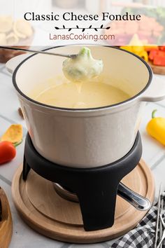 Fondue pot filled with cheese fondue and a fondue fork dipping a broccoli floret.