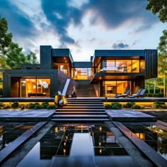 a modern house with stairs leading up to the upper level and pool in front of it