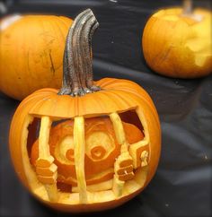 two carved pumpkins sitting on top of a table