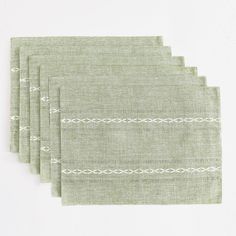 four placemats in light green linen with white stitching