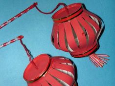 two red lanterns with tassels are on a blue surface