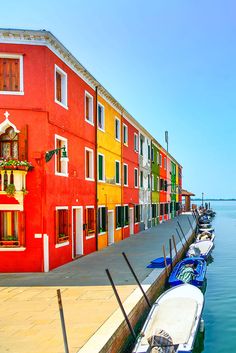 several boats are docked in the water next to colorful buildings