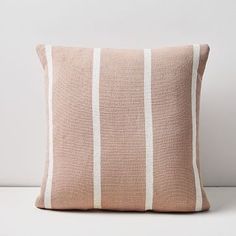 a beige and white striped pillow sitting on top of a table