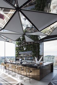 an outdoor bar with lots of chairs and umbrellas hanging from it's ceiling