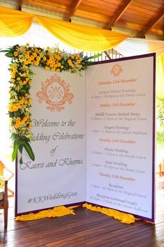 a wedding ceremony with yellow flowers on the front and back of an open fold up sign