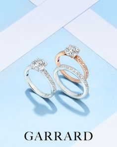 two diamond rings with the words garrad written below them on a blue and white background