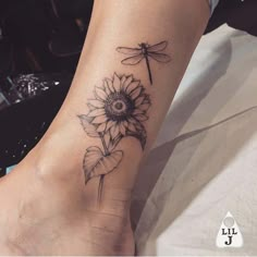 a sunflower with a dragonfly tattoo on the side of her leg and foot