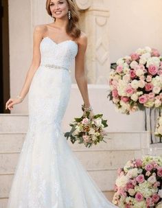 a woman in a wedding dress is standing on the steps with flowers and bouquets