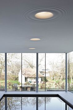 an indoor swimming pool in front of large windows